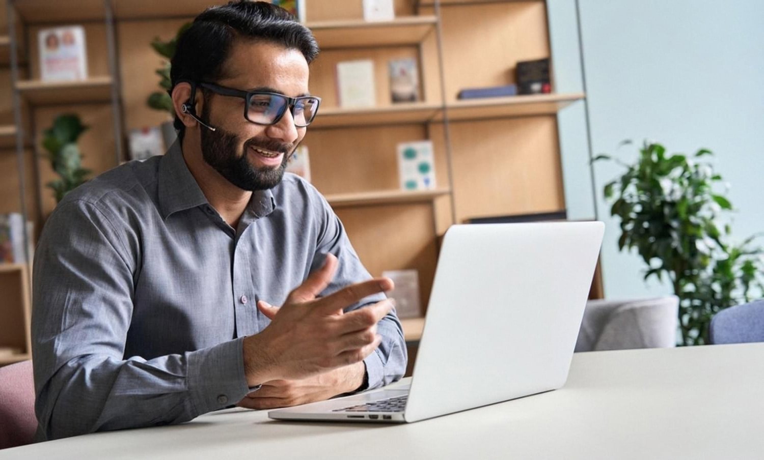 Man in Dubai attending an online course on a laptop with a headset